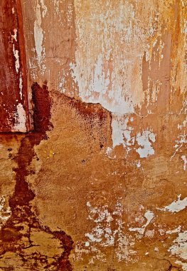 Eski bir evin duvarındaki bir dokuyu kapatın, kahverengi, bej ve beyaz nüanslarla, zamanın giydiği 