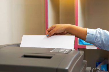 The secretary uses a copier to copy documents into a file to store in a system. soft and selective focus.                                clipart