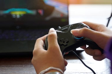 Bilgisayarda oyun kontrol etmek için joystick kullanan Asyalı çocuk. Yumuşak ve seçici odak.