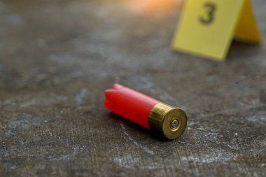 Mermi kovanları beton zemine düşer ve olay yerindeki kanıt numarasının bulanık arkaplanı. Soruşturma kavramı, adli tıp, kanıt, adli tıp..                               