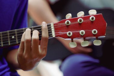 Bir adamın ukulele çalarkenki görüntüsü. Müzik çalma kavramı, boş zaman aktiviteleri, notalar, şarkılar                               