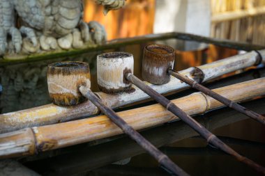 bamboo ladle is placed at a sacred pond in a Japanese shrine or temple. This is called shozuya. It is used to cleanse the body and mind before worship.                                clipart