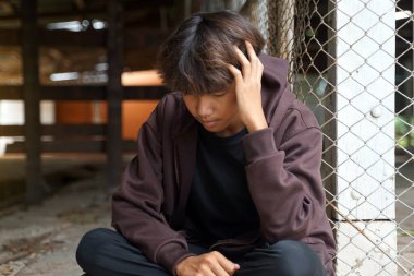 Kapüşonlu genç bir adam bir ıslahevinin köşesinde tek başına oturuyor. Gençlik kavramı, sorunları olan, düşünen, yalnız..                               