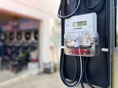 Binanın önündeki bir direğin üzerindeki dijital elektrik sayacı bir elektronik enerji ölçüm cihazıdır. Su ve elektrik kullanımını otomatik olarak kaydetmek için tasarlanmıştır..