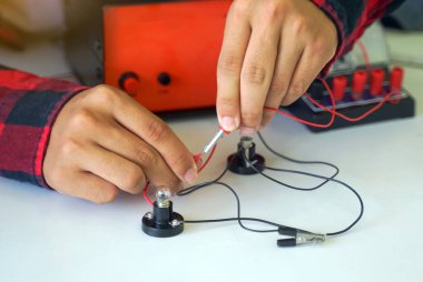 Öğrenciler basit elektronik devrelerle deney yapıyorlar. Trafik lambası devrelerinin prensipleri. Yumuşak ve seçici odak.                               