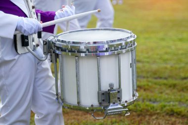 Marching band drummer plays music during the school sports day parade. Soft and selective focus.   clipart