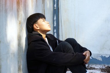 Genç bir çocuk oturur, sırtını terk edilmiş bir binanın duvarına dayayıp dizlerine sarılır, tek başına. Yalnız, terk edilmiş, karantinaya alınmış, depresyonda.                               