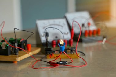 Ampulün parlaklığı, seri olarak bir elektrik devresine bağlandığında ve elektrik devresine bağlandığında voltmetre, ammetre, kablolar ve elektrik köprüsü de dahil olmak üzere bir dizi ekipmana bağlandığında.                         