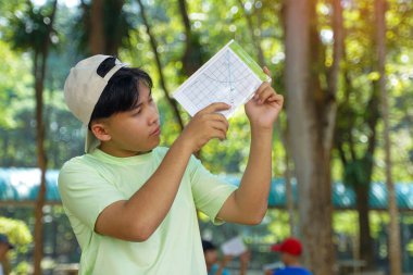 Çocuklar ağaçların yüksekliğini ölçmek ve ağaçların karbon depolamasını hesaplamak için bir klinometre kullandılar..                                