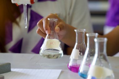 Asit bazlı titre deneyi yapan bir öğrencinin yakın çekimi. Kimya laboratuvarı kavramı, bilim, deney, beceri, öğrenme.                               