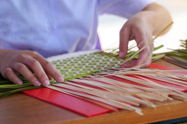 Öğrenciler geleneksel Tayland el işi olan bambu sepetleri dokuyorlar. Yumuşak ve seçici odak.                               