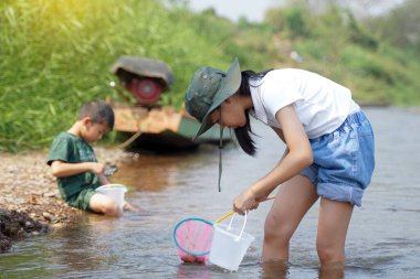 Çocuklar nehrin ekosistemini keşfetmek için balık ağlarını kullanırlar. Açık hava aktiviteleri, keşif, doğa, öğrenme kavramı                               