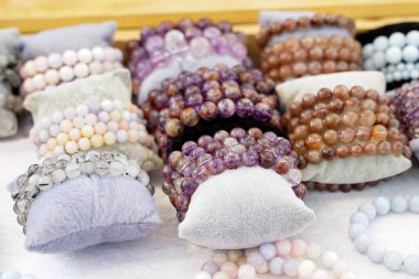 Renkli doğal taş bilezikler. Takan kişi, uğurlu taş bileziklerin enerjinin artmasına ve aşk, eğitim, sağlık, finans ve çalışmada şansın artmasına yardımcı olacağına inanıyor..                               