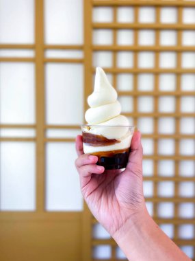 Elinde bir fincan Hokkaido taze süt incili yumuşak dondurma, Japon usulü yumuşak, kokulu, tatlı ve ferahlatıcı bir dondurma..