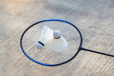 Beton arka planda badminton raketi üzerinde 2 mekik horozu, açık havada badminton oynamak için konsept, yumuşak ve seçici odaklanma.                                
