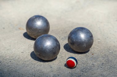 Petanque topları, 13 'e ulaşan hedef takıma mümkün olduğunca yakın 12 yuvarlak metal topun atıldığı bir açık arazideki hedef topun yanına yerleştirilir. İlk golü atan kazanır..                               