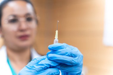 Hastalık tedavisi için elinde şırınga tutan doktor.