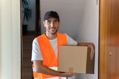Teslimatçı eve paket getiriyor. Boşluğu kopyala