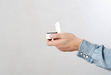 Evlilik teklifi. Adamın eli yüzükle evlenme teklif ediyor. Beyaz ve soyutlanmış arka plan. Romantik konsept, mücevher almak, gelin ve damat için düğün planları.