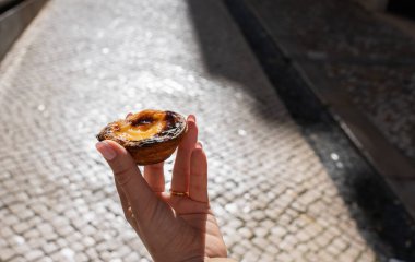 Geleneksel pastel de nata ya da kadınların elinde pastel de Belem. Geleneksel Portekiz hamur işleri.