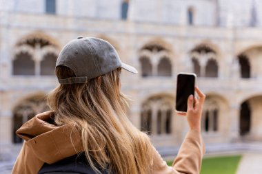 Bir turist cep telefonuyla Avrupa 'nın mimari ve simgesel anıtlarının fotoğraflarını çekiyor..