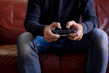 PlayStation 'da oynayan bir adamın ellerinin yakın plan çekimi..