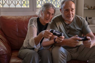 Emekli yaşlı çift evde birlikte vakit geçiriyor.