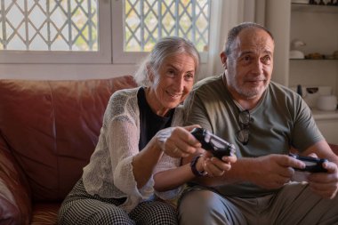 Emekli yaşlı çift evde birlikte vakit geçiriyor.