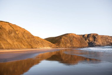 Deniz suyundaki kayalık dağların yansımasının geniş açılı panoramik görüntüsü