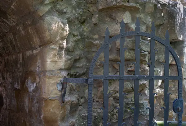 Alman şatosunun harabelerinde siyah renkli demir bir kapı.