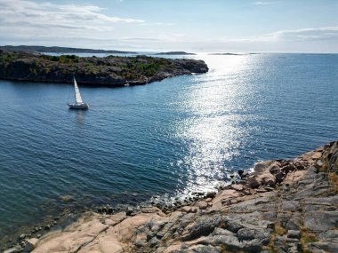 İsveç, Bohuslan 'da iki ada arasında bir yelkenli yelken açar..