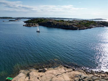 İsveç, Bohuslan 'da iki ada arasında bir yelkenli yelken açar..