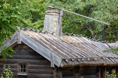 Üzerinde taş ve ahşaptan yapılmış uzun bir baca bulunan sazdan çatılı bir ahşap kulübe. Kulübe bereketli yeşilliklerle çevrili. Huzurlu bir doğal ortam sergiliyorlar..