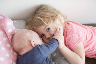 Ablam küçük kardeşime bakıyor. Kardeş ilişkisi. Kız kardeşinin sevgisi. Evde yeni bebek var.