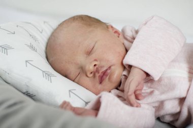 Kafkasyalı yeni doğmuş bebek bebek, bebek odasında pembe bir kıyafetle huzur içinde uyuyor. Uyuyan bebek konsepti