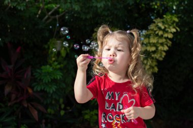 Domuz kuyruklu, baloncuk çıkaran beyaz bir kız. Yaz ailesi eğlence konsepti