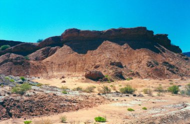 Very eroded desert area with some bushes clipart