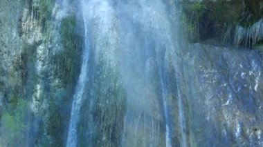 Dağdaki şeffaf şelale buhar bulutları oluşturuyor..