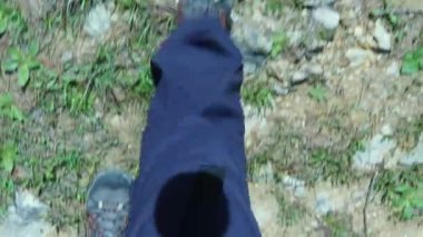 Dağ ayakkabılarıyla bir çayırda yürüyorum