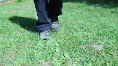 Dağ ayakkabılarıyla çimenlerde yürüyorum.