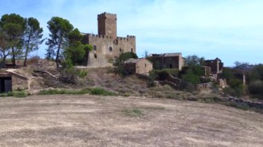 Tarlaların arasında, bulutlu bir geçmişi olan dört köşeli eski bir askeri kale..