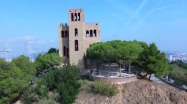 Arka planda ağaçlar ve dağlar arasında yarı terk edilmiş bir kule..