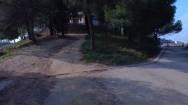 Antik kule, arka planda dağlarla ağaçların arasında beliriyor..