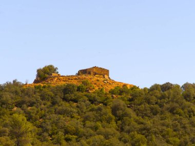 Bir dağın tepesindeki ortaçağ şatosunun kalıntıları..
