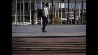 Yelkenli limanının yanında gezinen insanlar.