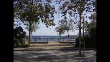 Arka planda denizle yürüyen insanlar..