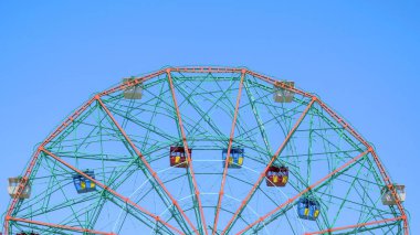 Mavi gökyüzüne karşı yarım dönme dolabın fotokopi için yeri olan fotoğrafı..