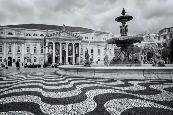 stock image Lisbon, Portugal - April 21, 2022: National Theatre and fountain in Rossio Square. Baixa neighborhood of Lisbon. In Black and White.