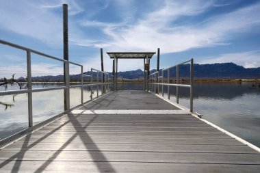 Remote location boat launch pier Arizona route 66 blue sky clouds.