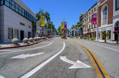 Rodeo Drive alışveriş bölgesi lüks butikler, palmiye ağaçları ve pankartlarla dolu..